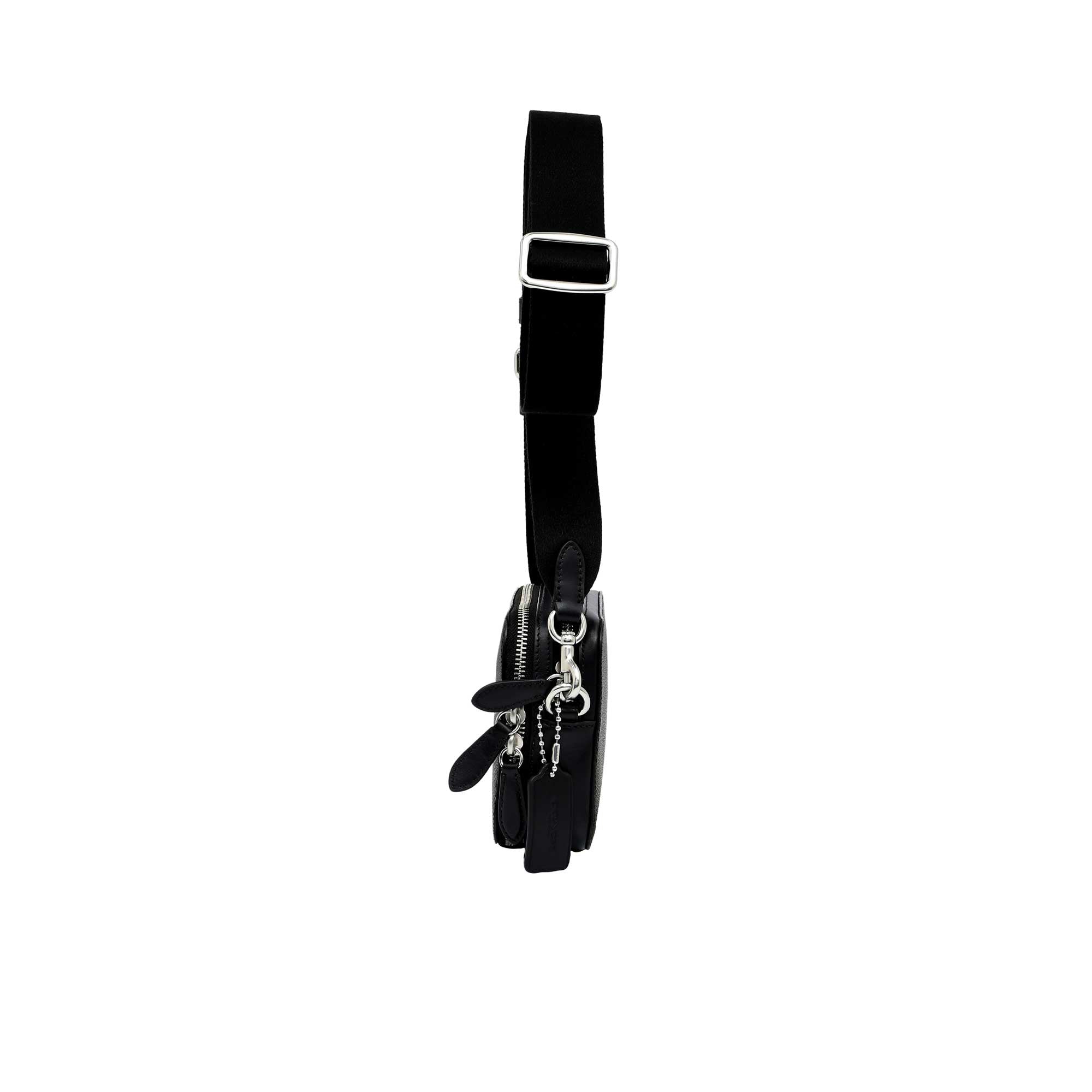 Side profile view of the black Coach Tabby messenger bag showing its expandable multi-gusset structure, neat finished edges, and the black dogleash clasp attaching the wide strap.