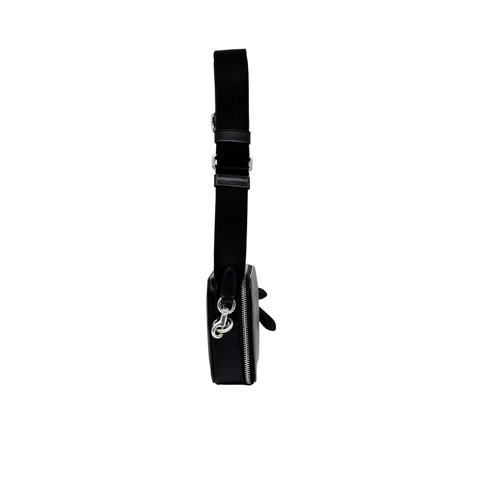 Side profile view of the black Coach Tabby messenger bag showing its expandable multi-gusset structure, neat finished edges, and the black dogleash clasp attaching the wide strap.