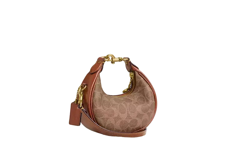 Side-angle view of the Coach Lana 23 shoulder bag in signature canvas and white leather, showing the sculptural depth and detachable strap.