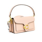 Side profile view of the silver mini Coach Tabby bag displaying the dual-gusset expandable structure, painted edges, and polished silver dogleash swivel clips on the detachable handle.