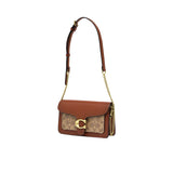 Side view of the metallic silver Coach Tabby bag showing the dual-gusset expandable structure, smooth hand-painted edge stains, and secure silver dogleash clips holding the detachable top handle.