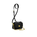 Side view of the metallic silver Coach wristlet displaying its slim, expandable gusset design and hand-painted edges with polished silver hardware attachment clips.