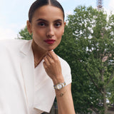 Still life collection layout showcasing the Marina gold bracelet next to its matching monogram necklace, earrings, and a luxury watch.