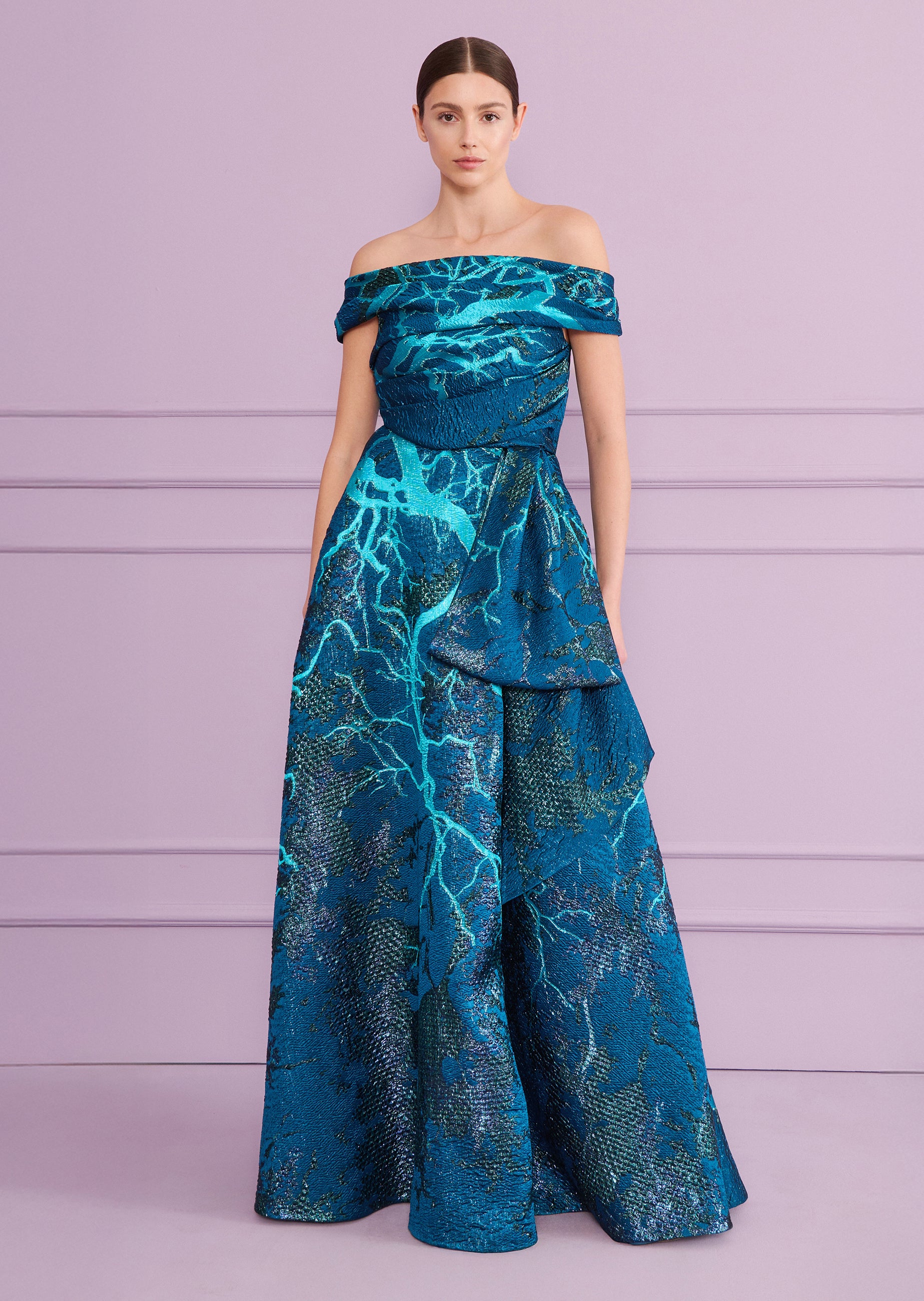 Teal off-the-shoulder long dress with a textured, shimmering branch-like pattern in blue and metallic threads, featuring a dr