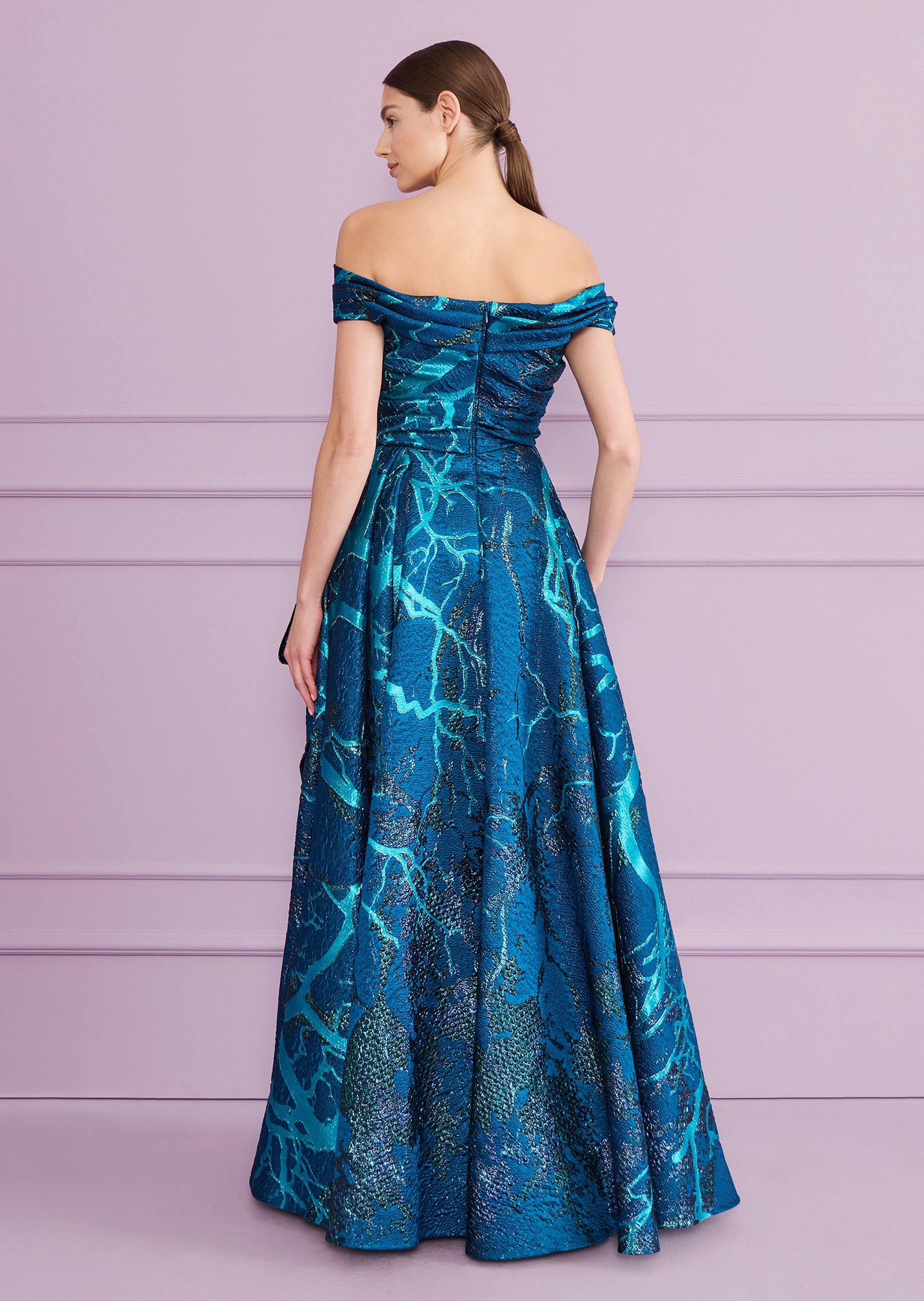 Teal off-the-shoulder long dress with a shimmering, abstract blue-green pattern. Features a ruched bodice, full skirt, and ba