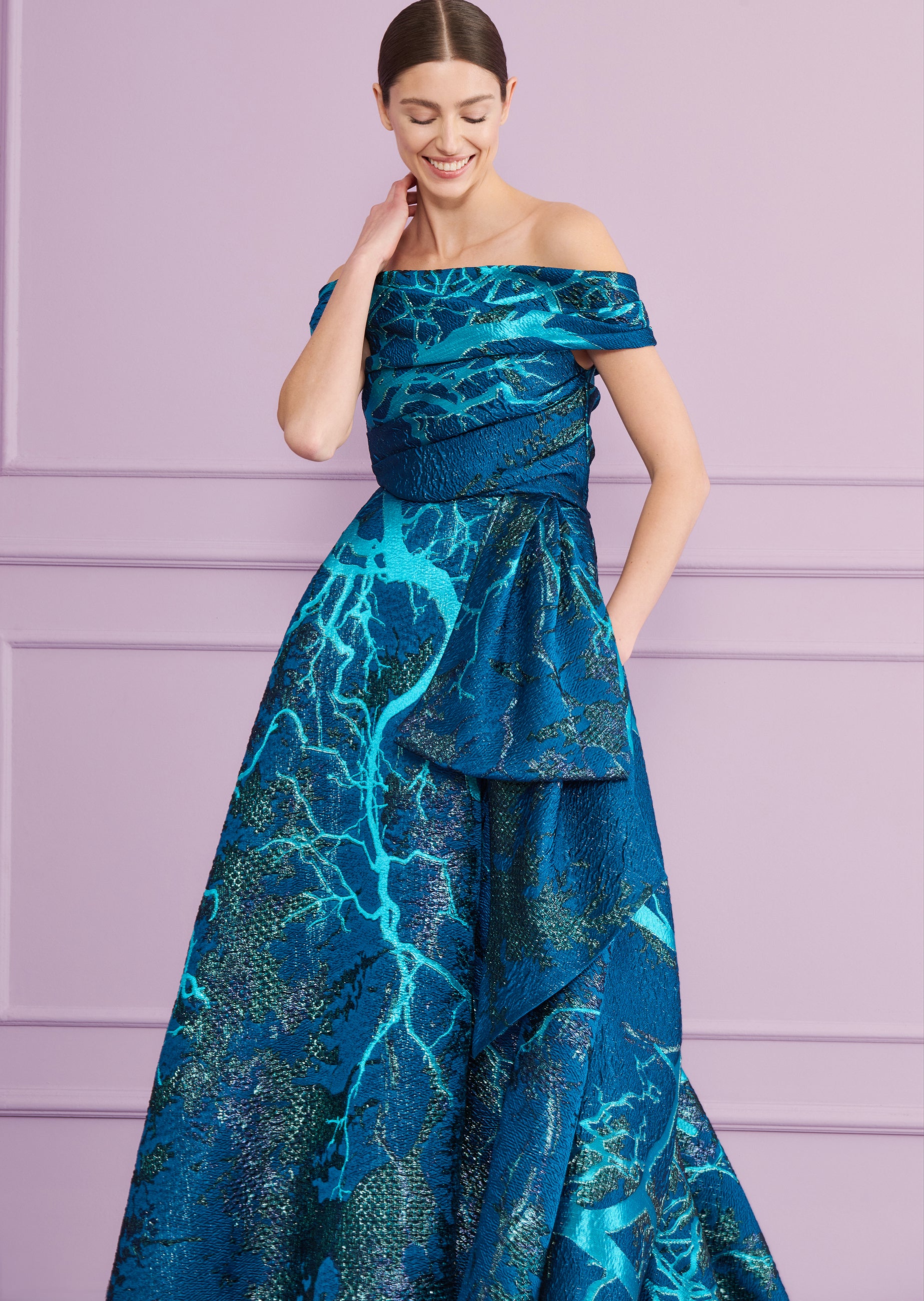 Teal and dark blue off-the-shoulder long dress with a shimmering abstract branch pattern. Features a ruched bodice, defined w