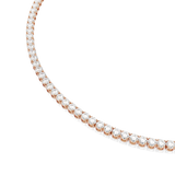 A precise studio close-up of a curved section of the Swarovski Matrix tennis necklace, detailing the crisp faceting of the round white crystals and the smooth articulation of the 18K rose gold-finish joints.