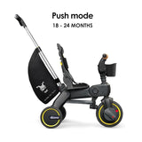 Black and dark gray Doona Liki Trike S5 with yellow wheel rims, red front wheel accents, silver-toned push handle, and a blac