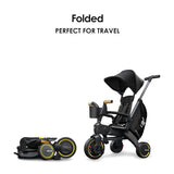 Black Doona Liki Trike S5 with black canopy, seat, and storage bag, yellow wheel accents, and wood-toned grips, shown both as