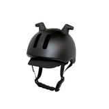 Black Doona Liki children's helmet with a matte finish, two ear-like protrusions, front ventilation slots, and a fabric visor