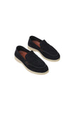 Pair of dark blue suede moc-toe loafers with cream soles, visible stitching, and small gold-toned rectangular accents on the