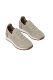 Pair of beige knitted slip-on runner shoes with ribbed details on the upper, light brown heel accents, white midsoles, and da