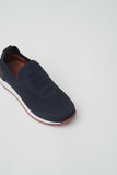 Navy knit slip-on shoe with ribbed upper, white midsole, and maroon outsole. Brown interior lining.