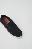 Navy suede slip-on loafer with moccasin toe stitching, three side stitches, a light cream sole, and a brown insole.