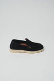 Dark blue suede slip-on loafer with a light beige sole, light brown trim, and three small rectangular details on the side. 'S