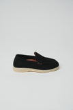 Black suede loafer with a light beige sole, a small dark logo on the outer heel, and three tan rectangular accents on the sid
