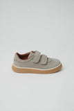Taupe suede low-top sneaker with two hook-and-loop straps, brown interior lining, and a thick light brown sole with a white s