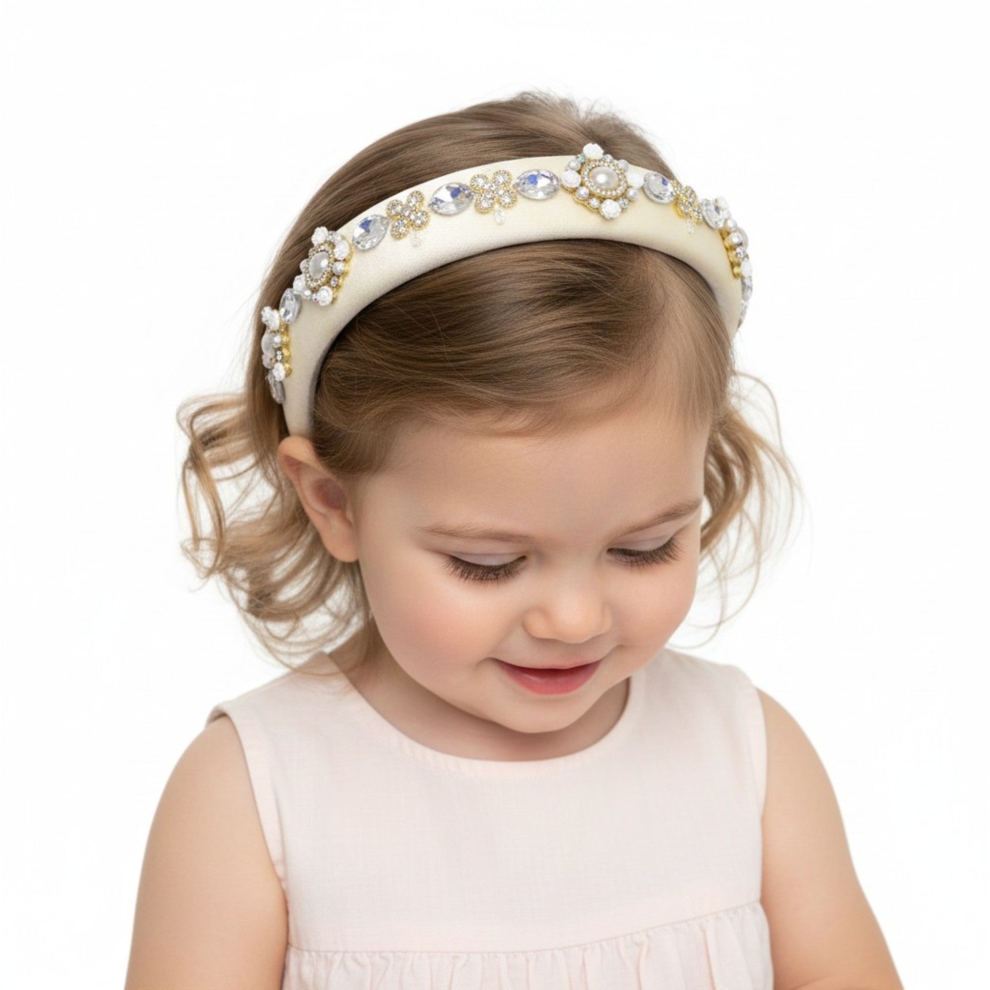A young girl with dark curly hair looking back over her shoulder, wearing the colorful  Carretto print top-knot headband.