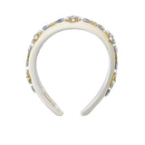 Front view of the David Charles white cotton poplin headband, showcasing the vibrant, colorful Carretto geometric pattern and central top knot.