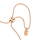 A macro close-up view of the Swarovski Mesmera bracelet's adjustable sliding bead fastener, showing the high-shine 18K rose gold finish and the dangling chain ends tipped with a branded octagonal tag.