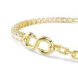 A detailed macro close-up shot focusing on the focal centerpiece of the Swarovski Matrix bracelet, emphasizing the smooth contours of the gold-plated infinity symbol meeting the row of round-cut white crystals.