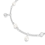 A detailed macro close-up shot focusing on the charms of the Swarovski Imber bracelet, emphasizing the smooth surface of the white crystal pearls alongside the flawless bezel setting of the round clear crystals.