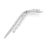 A dynamic three-quarter perspective studio view of the Swarovski Mesmera brooch resting on a flat surface, illustrating the dimensional depth of the mixed-cut crystals and how the clear stones catch the light.