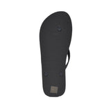 Black flip-flop slipper, bottom view. The sole has a ridged texture with three circular strap anchors and a small label at th