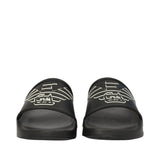 Pair of black slide slippers with a white eagle and 'EA' logo on the top strap of each slipper.