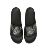 Black slide slippers with wide top straps, each displaying a white outlined eagle logo with 'GA' text.
