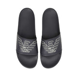 Pair of black slide slippers with a wide strap, each featuring a white outline eagle logo with 'GA' initials.