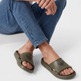 Chunky olive green rubber slide slippers, each with a wide top strap and a dark circular eagle logo.