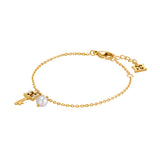 Gold-toned chain bracelet with a key charm, a white pearl, and a small rectangular logo tag.