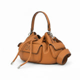 Right three-quarter angled view of the Ermanno Firenze tan drawstring bag at BLUE SALON, showcasing the slouchy silhouette, side flap pockets, and long metal-tipped drawcords.