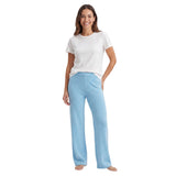 Woman wearing a white t-shirt and light blue pants on a white background.