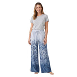 A smiling model wearing the Ermanno blue ombré floral wide-leg trousers from BLUE SALON shop, paired with a simple grey t-shirt.