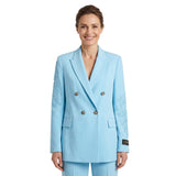 Woman wearing a light blue suit with embroidery on a white background.