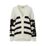 A white and black striped V-neck cardigan by ERMANNO FIRENZE with intricate black floral lace embroidery on the sleeves.