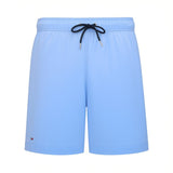 Light blue men's swim shorts with an elasticated waistband, dark navy drawstring, and small brand flag emblem on the left leg