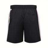 Back studio shot of the men's Eden Park black swim shorts, highlighting the pale pink side panels, a single rear welt pocket, and retail attached tags.