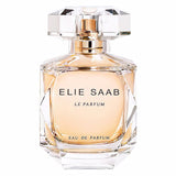 Front view of the Elie Saab Le Parfum Eau de Parfum 90ml bottle against a plain white background. The bottle is crafted from clear, heavy faceted glass resembling a cut gemstone, revealing the peach-colored liquid inside. It features a transparent, geometric crystal-like cap with a gold dispenser underneath, and 'ELIE SAAB LE PARFUM EAU DE PARFUM' printed in black lettering across the front.