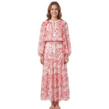 Full-length front view of a smiling model wearing the Ermanno Firenze coral pink and cream floral maxi dress with tassel neck ties from BLUE SALON shop.