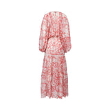 Studio rear view of the Ermanno Firenze coral pink printed maxi dress showcasing the fluid drape of the pattern and tiered panels from BLUE SALON shop.