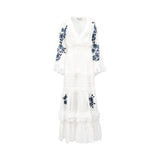 Front view of an Ermanno white maxi dress featuring blue botanical embroidery on the bell sleeves and tiered ruffled skirt from BLUE SALON shop.