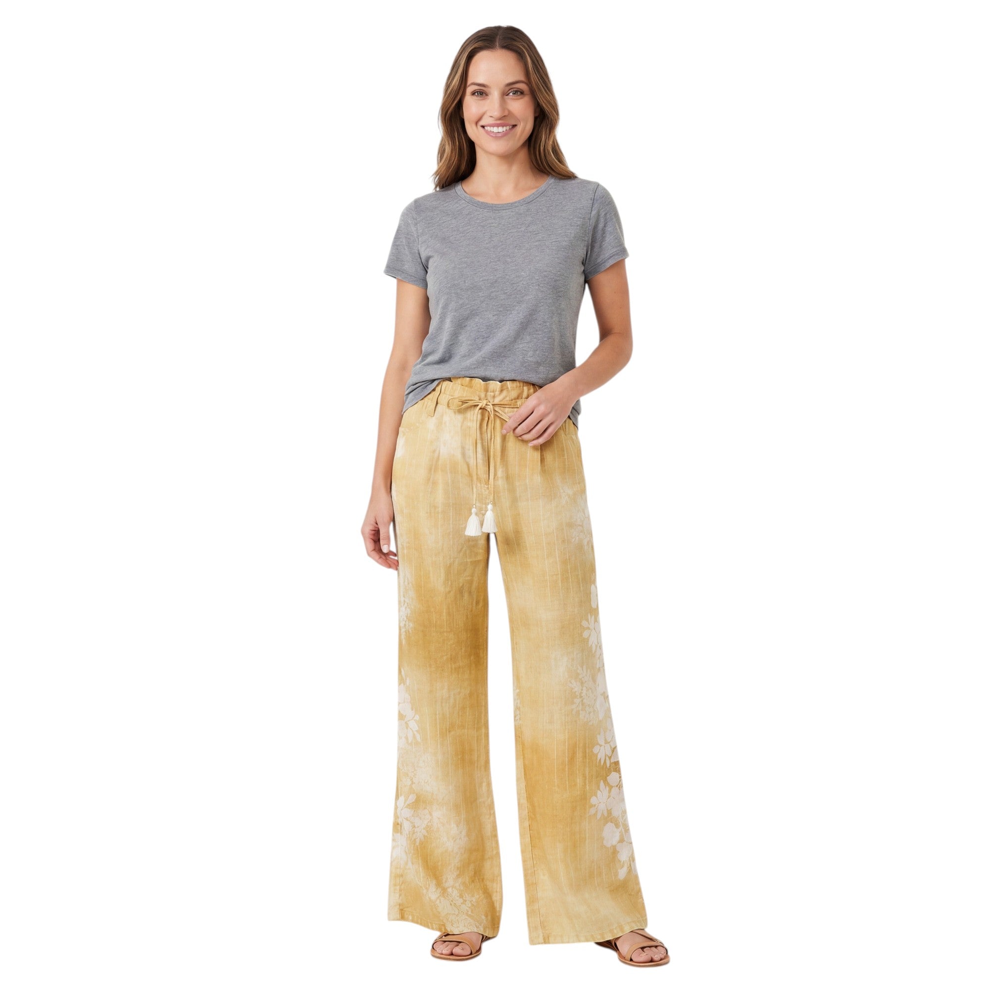A smiling model wears the flowing Ermanno Firenze wide-leg yellow linen trousers paired with a gray t-shirt and sandals, from BLUE SALON.