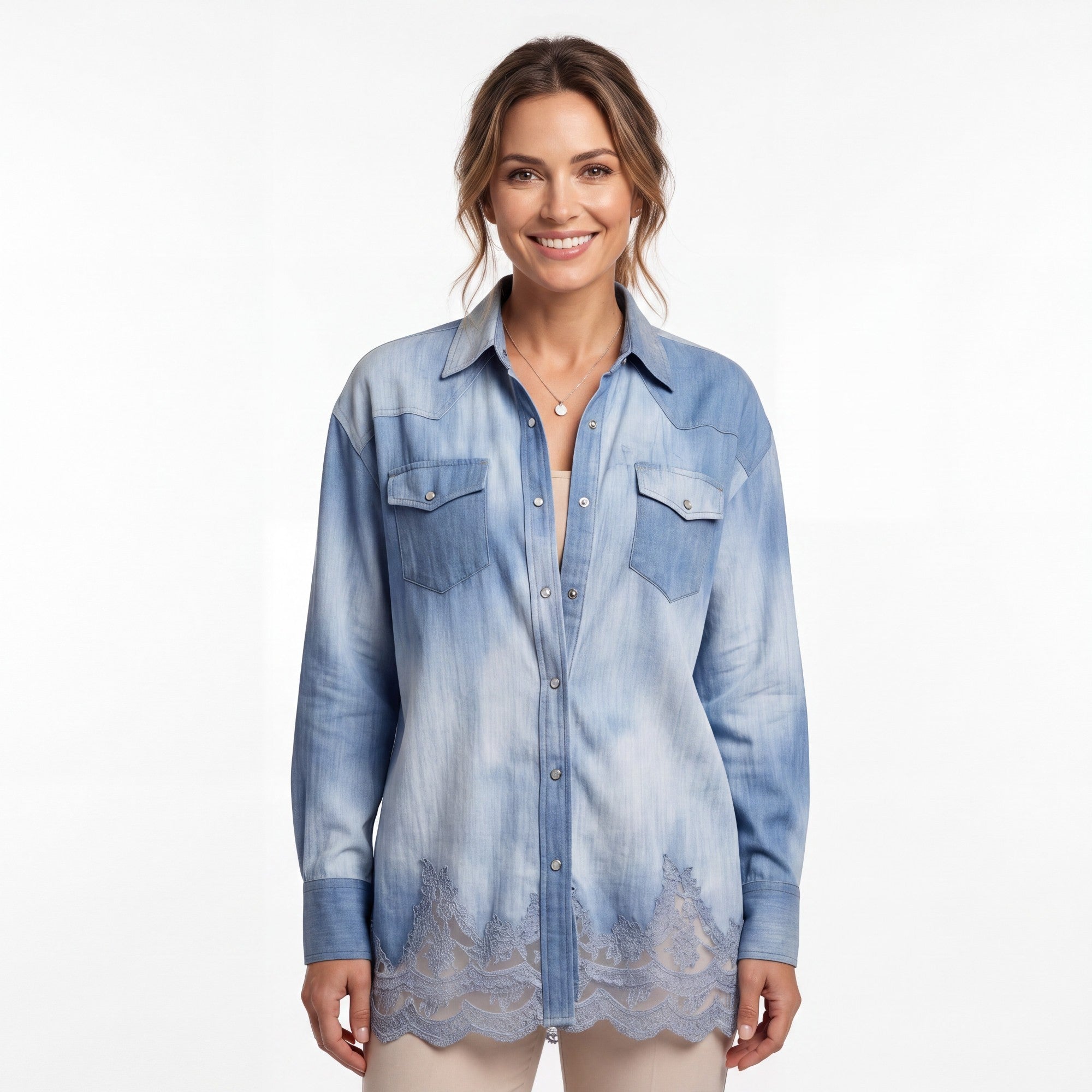 Front view of a smiling model wearing the Ermanno Firenze light blue chambray shirt unbuttoned over a camisole and paired with light neutral trousers.