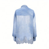 Rear studio view of the Ermanno Firenze blue chambray shirt showcasing the clean back panel, western yoke detailing, and transparent scalloped lace border.