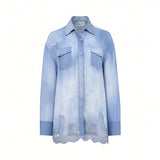 Front studio presentation of the Ermanno Firenze light wash chambray shirt highlighting its western yokes, chest pockets, and intricate floral lace hemline.
