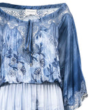 Blue floral embroidered top with white pleated skirt on a white background.