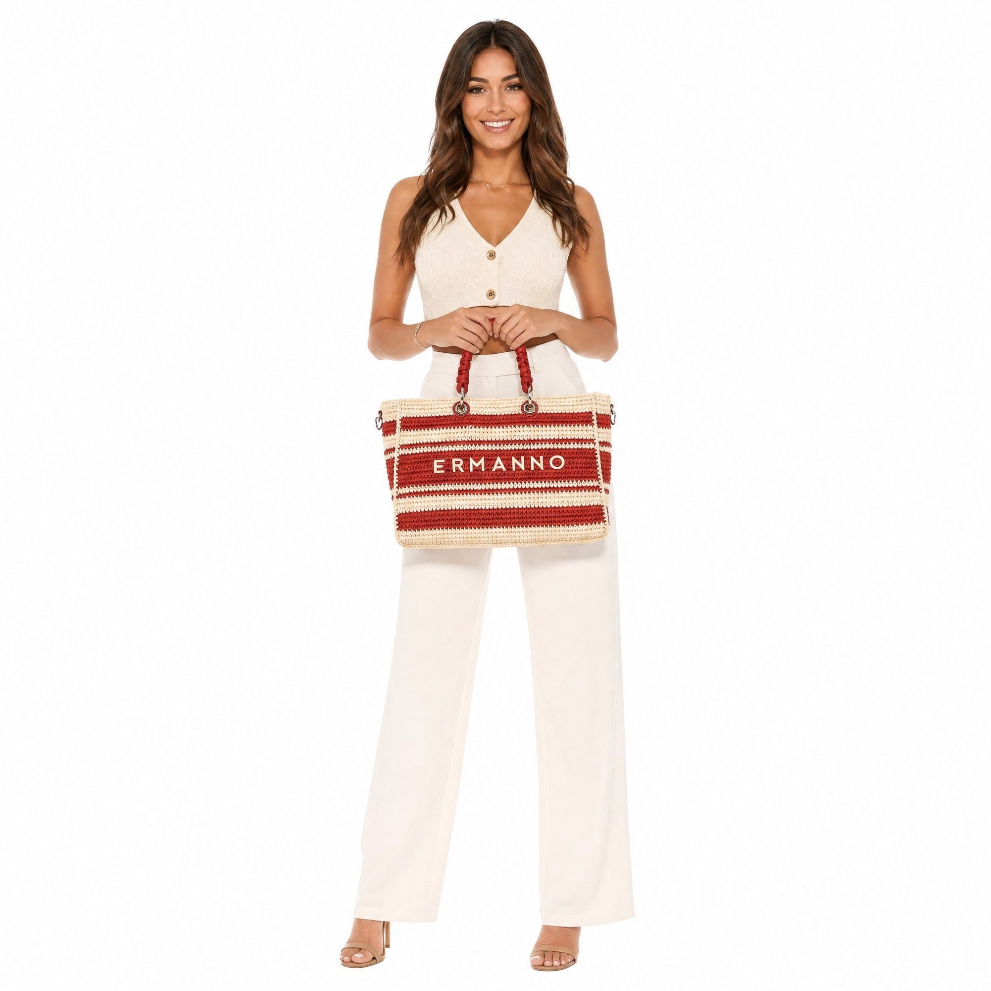 Woman holding a red and beige bag with 'Ermanno' branding on a white background.